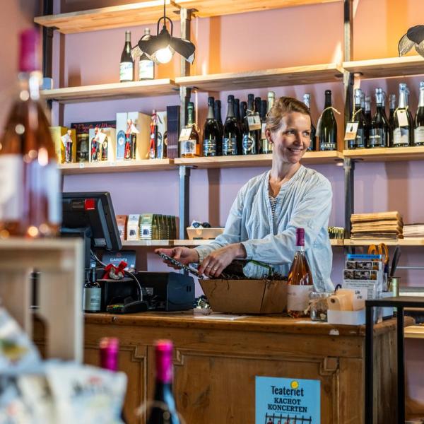 Kvinde står bag skranke i butik