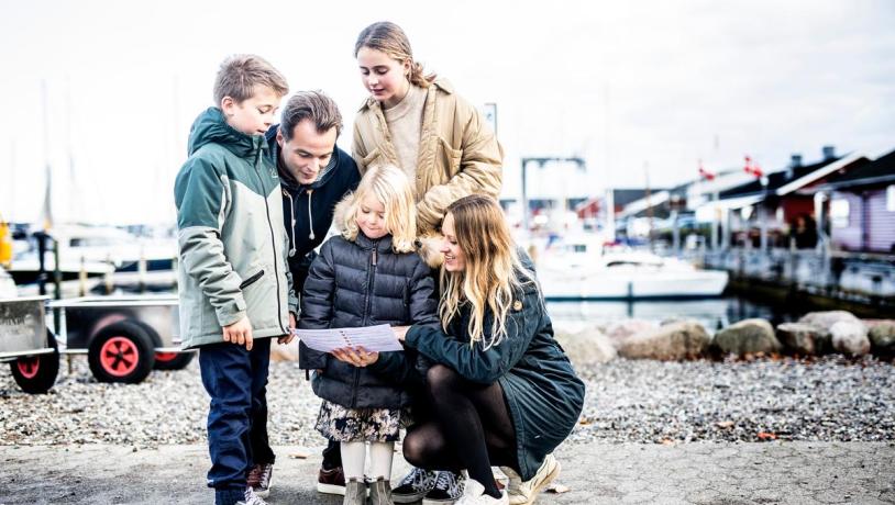 Familie kigger på skattekort på Juelsminde Havn
