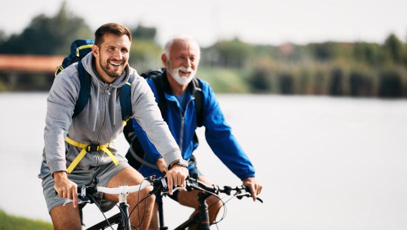 Far og søn cykler på elcykler ved vandet