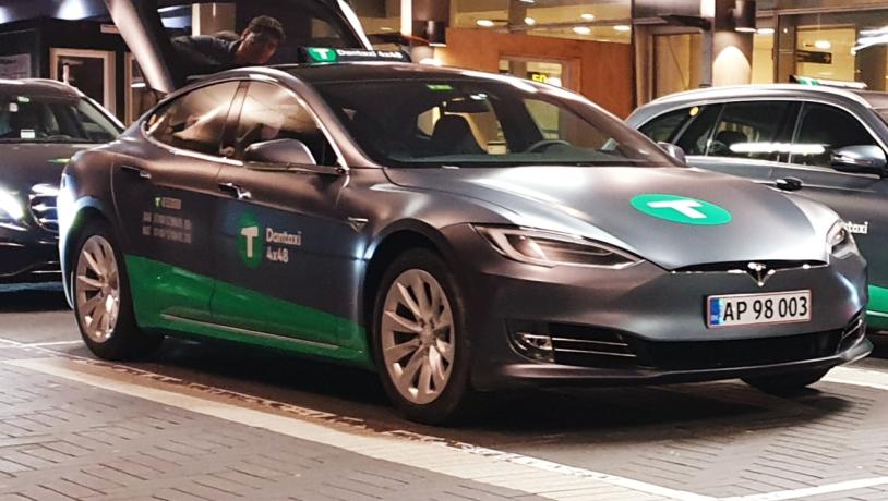 En Tesla fra Dantaxi holder i et parkeringshus