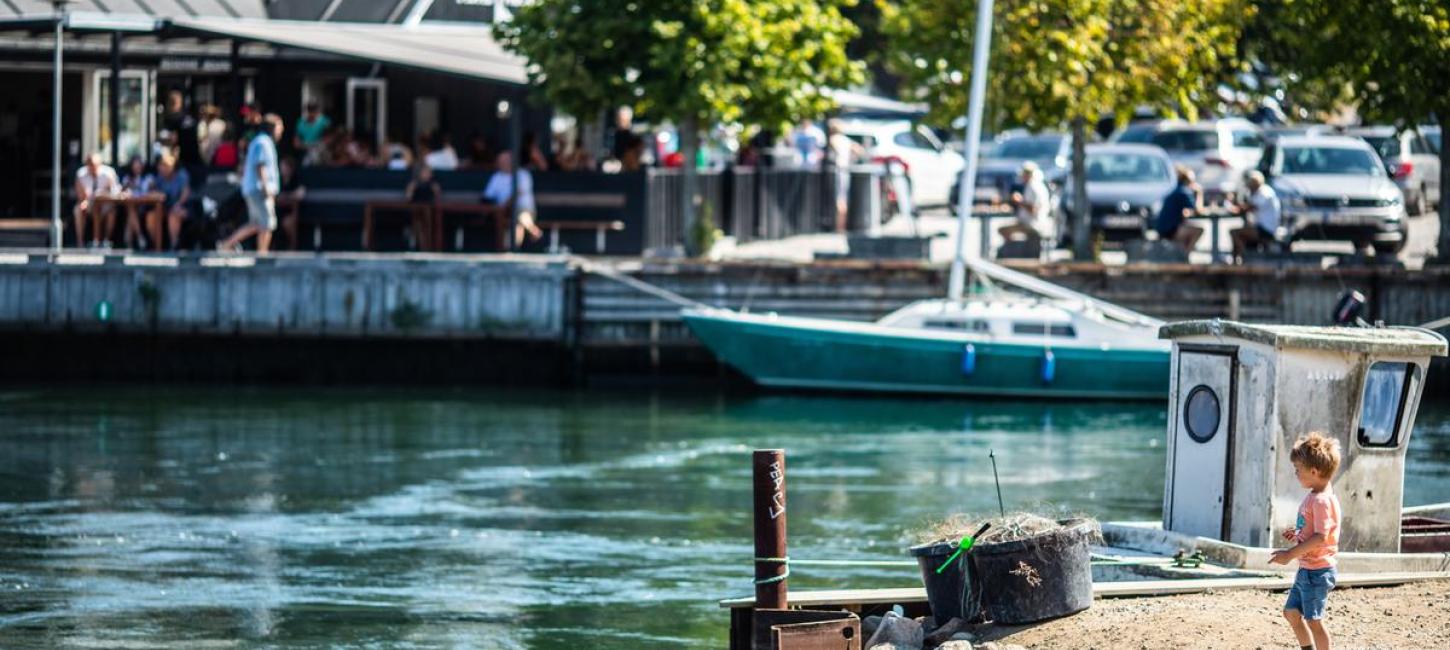Dreng står ved Norsminde havn