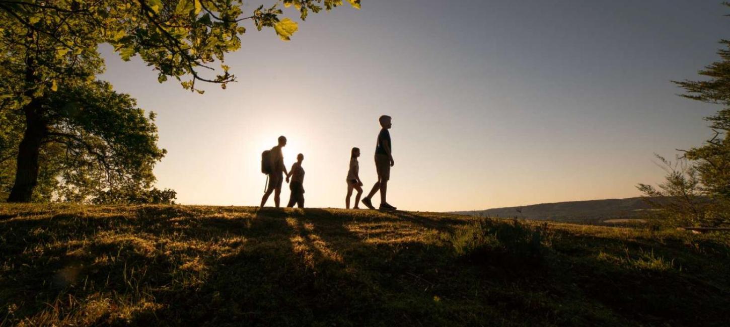 Familie går i solnedgang på Sukkertoppen