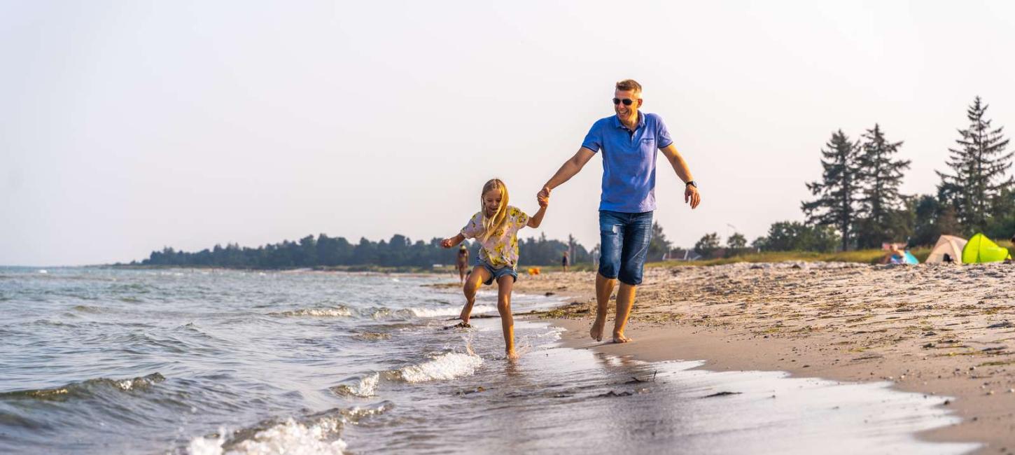 Far og datter i vandkanten ved Saksild Strand