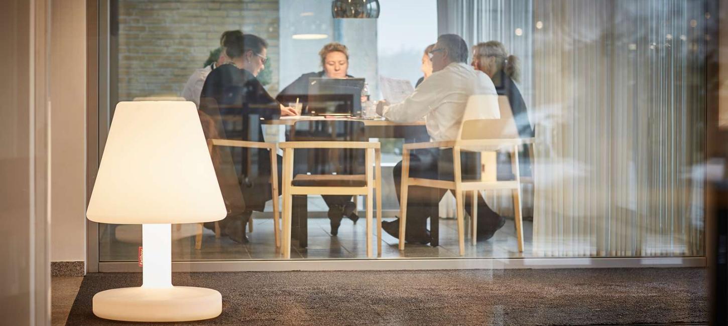 Aktivt møde i mødelokale bag glasvæg på Hotel Opus i Horsens - en del af Destination Kystlandet