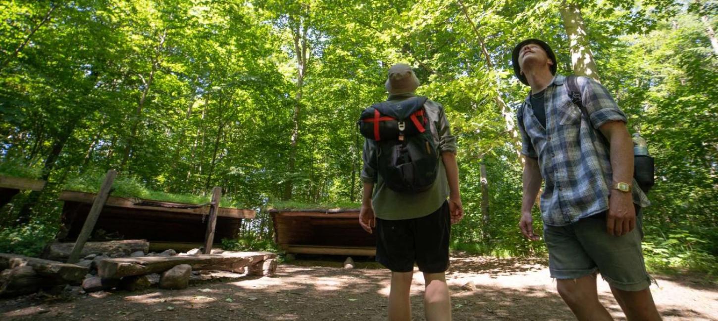 To mænd på vandretur ved shelterplads i skoven