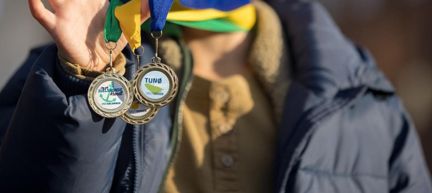 Skattejagten Rundt Destination Kystlandet dreng holder medaljer