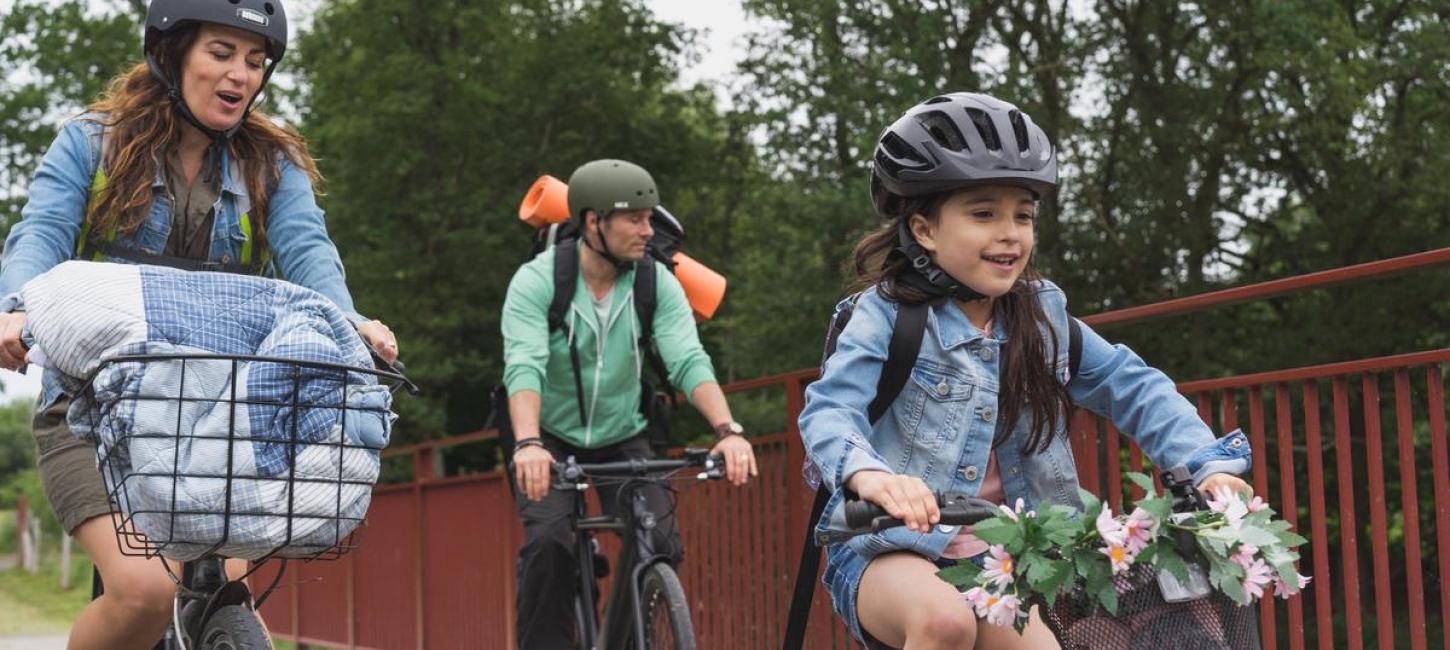 Familie af far, mor og pige på cykeltur på Bryrupbanestien ved Den Genfundne Bro i Kystlandet. 
