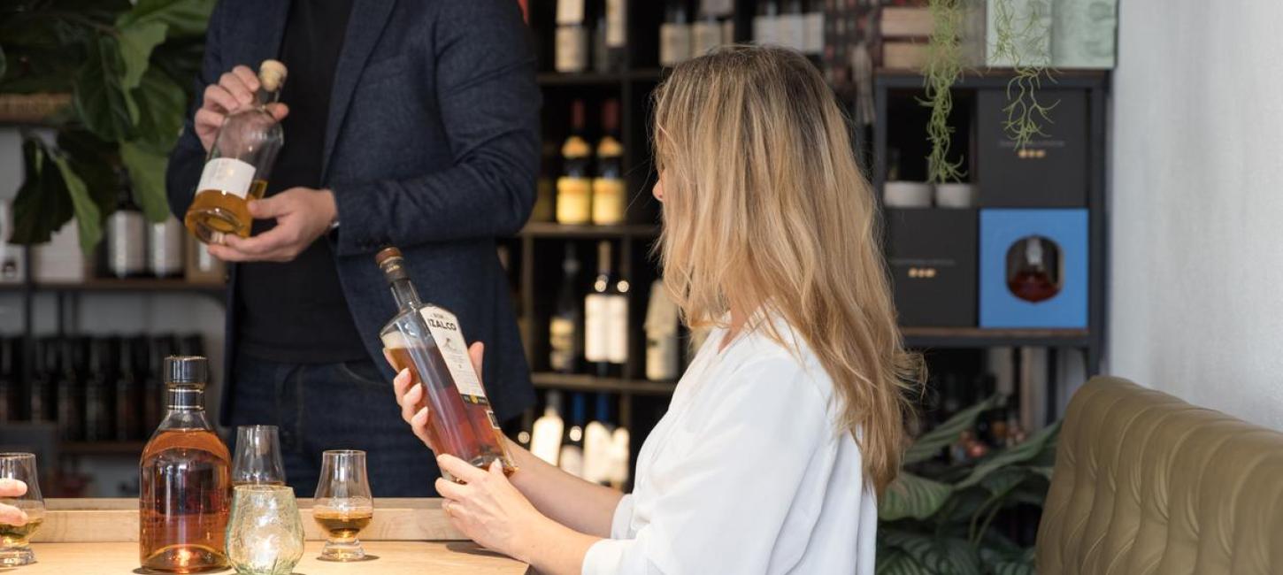 Dame holder en flaske whisky i specialbutikken Water Of Life på Mejeritorvet i Brædstrup