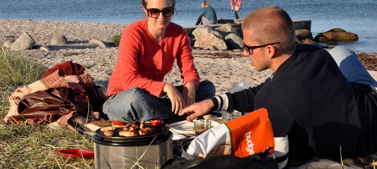Familie hygger og griller ved stranden ved Ajstrup Camping - en del af Destination Kystlandet