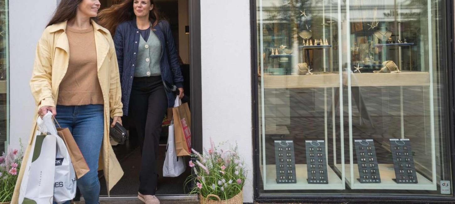 To kvinder med poser i hænderne på vej ud af butik i Horsens