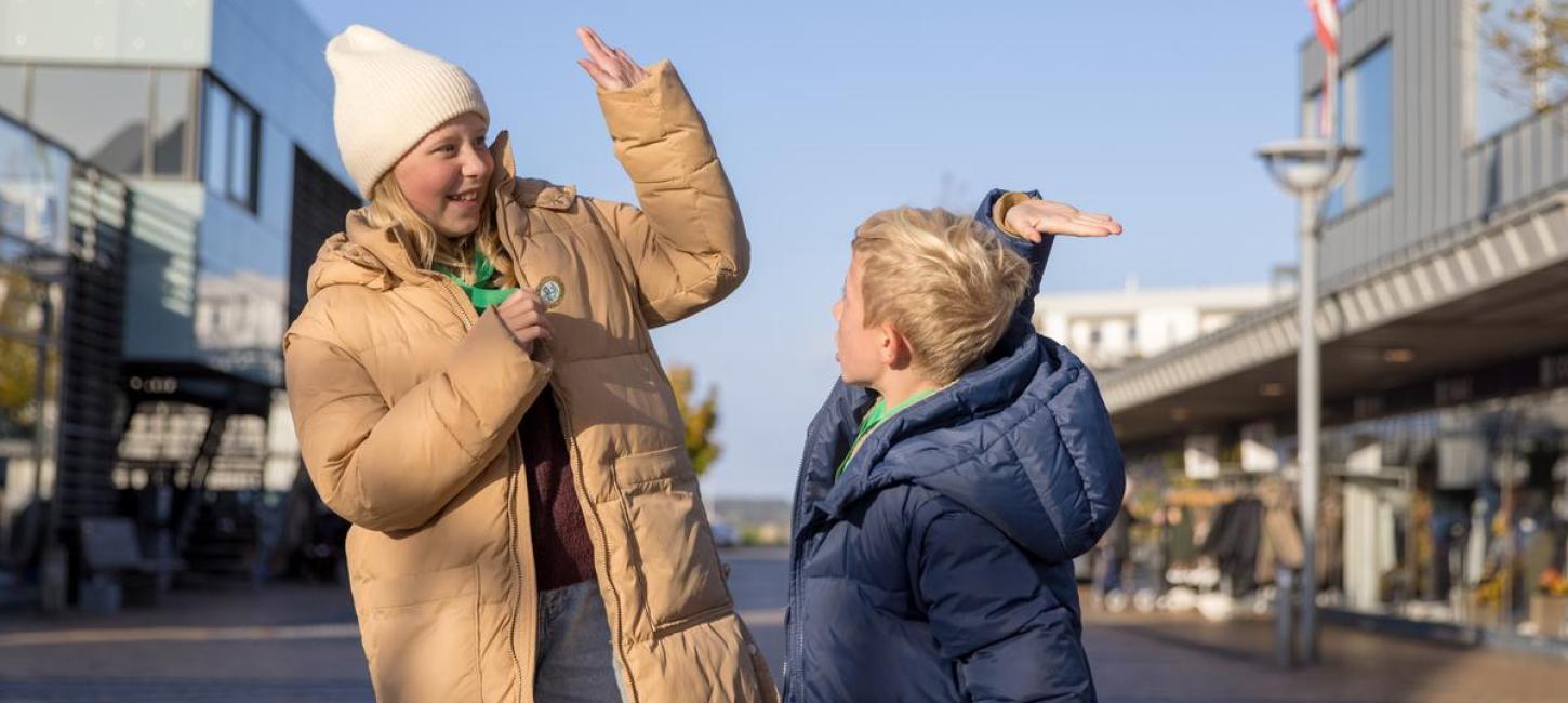 En pige og en dreng giver hinanden en highfive i Juelsminde med medaljer