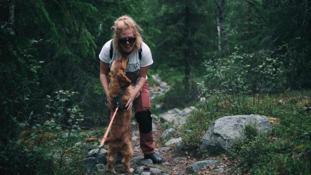 Kvinde krammer sin hund i skov