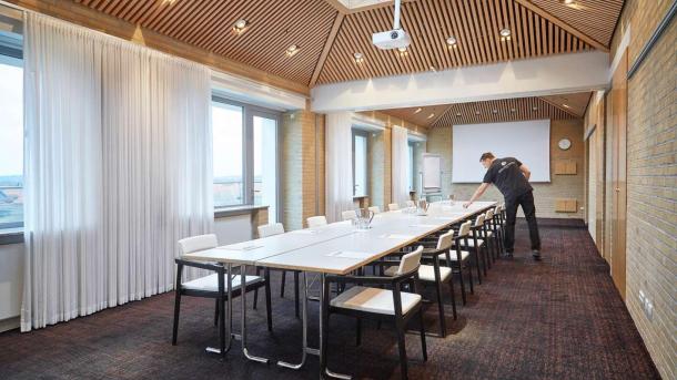Medarbejder forbereder mødelokale på Hotel Opus i Horsens