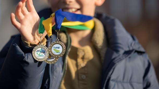 Skattejagten Rundt Destination Kystlandet dreng holder medaljer