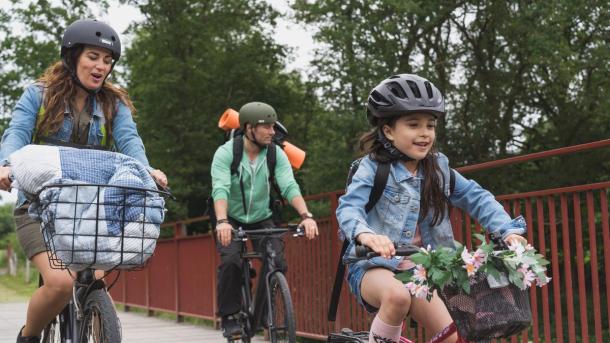 Familie af far, mor og pige på cykeltur på Bryrupbanestien ved Den Genfundne Bro i Kystlandet. 