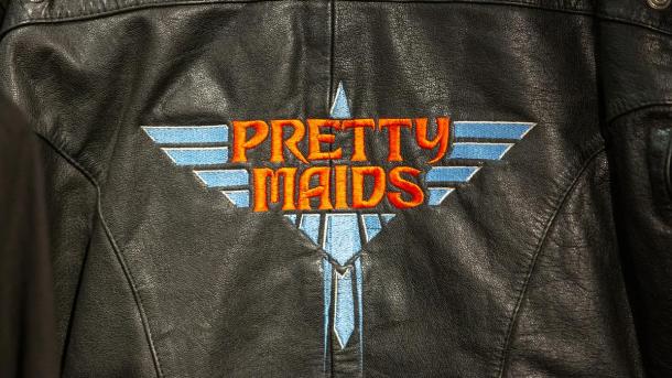 Sort læderjakke med Pretty Maids logo på ryggen i blå og rød