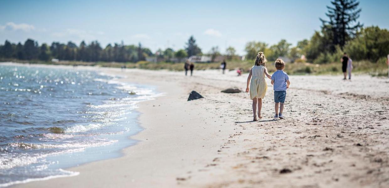 Børn går på stranden ved Saksild