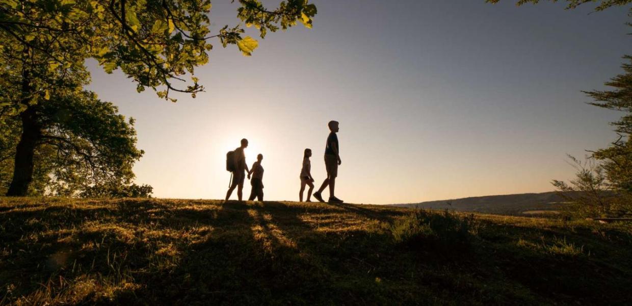 Familie går i solnedgang på Sukkertoppen