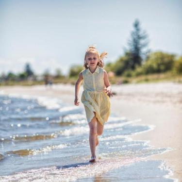 Pige løber på stranden ved Saksild