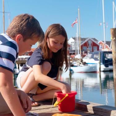 Børn med rød spand på havnen i juelsminde