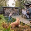 Familie hygger på terrassen i et feriehus i Kystlandet og pige leger med hund og ild i bålfad