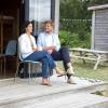 Par sidder og snakker foran hytte på Tunø Teltplads i Destination Kystlandet