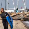 A woman walking with an SUP-board in Juelsminde