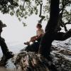 Woman sitting in a tree at Horsens Fjord in Denmark 