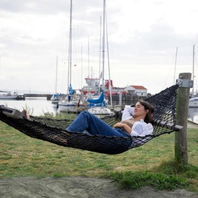 Kvinde slapper af i hængekøje på Tunø Havn - en del af Destination Kystlandet