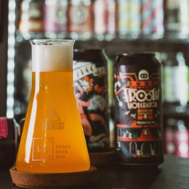 A carafe of pale beer standing on a table near a refrigerator with specialty beers at the Board Game Café in Horsens