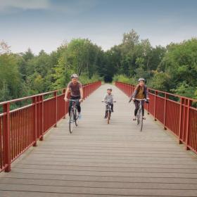 Familie cykler over Den Genfundne Bro