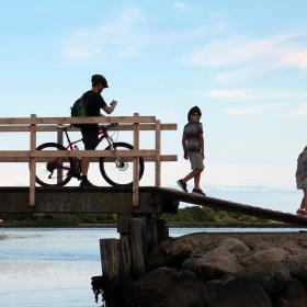 En mand på cykel og to børn på en bro på Hjarnø