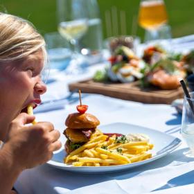 Dreng spiser burger og pommes frites på Mejeriet på Tunø der ligger i Destination Kystlandet