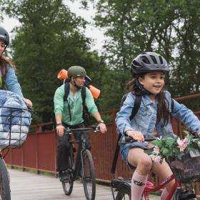 Familie af far, mor og pige på cykeltur på Bryrupbanestien ved Den Genfundne Bro i Kystlandet. 
