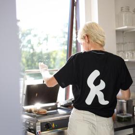 Kvinde er ved at lave en panini i caféen på Platform K i Horsens