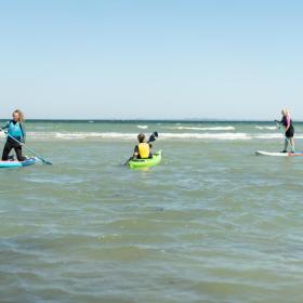 Women on SUP-boards and a man in a sea kayak at Saksild Beach