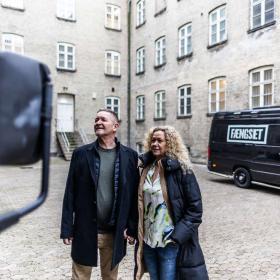 Mand og Kvinde kigger på en bil i en muret fængselsgård