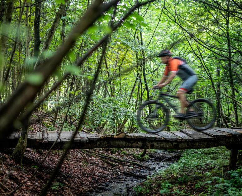 Mand kører over bro på mountainbike i Odder