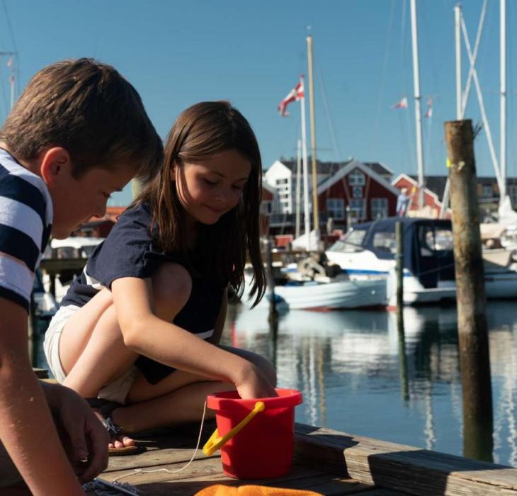 To børn fanger krabber på krabbebroen på Juelsminde Havn