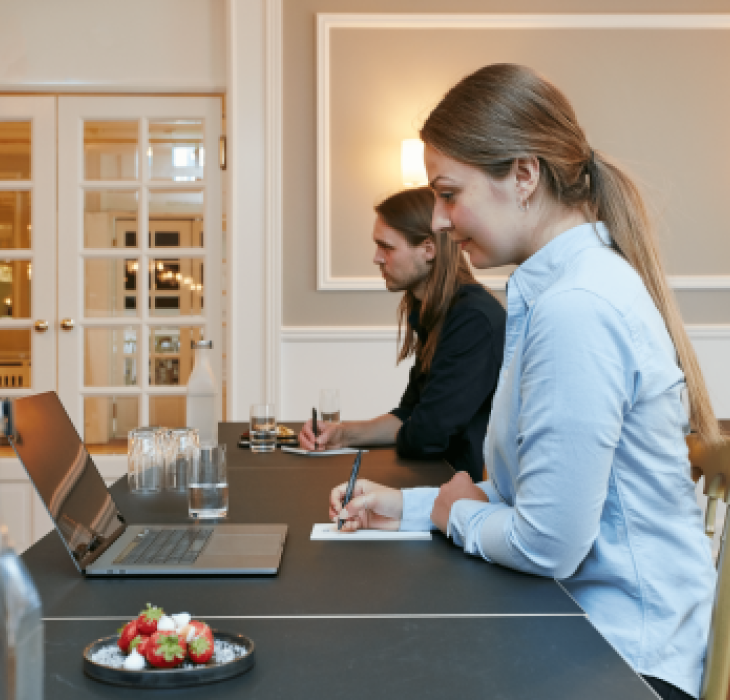 To mødedeltagere sidder ved bord til møde på Hotel Jørgensen i Horsens