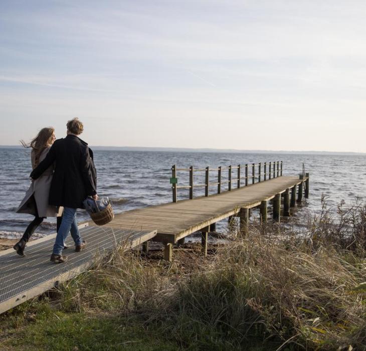 Par går med madkurv på mole ved Vejle fjord